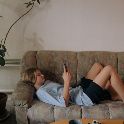 teenager on couch on phone